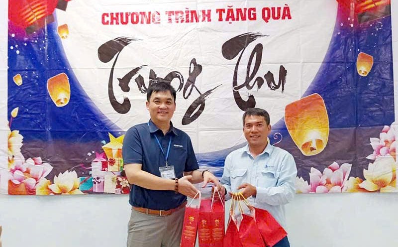 Mr. Tran Van Quang - Chairman of the Trade Union of Foster Quang Ngai Electronics Co., Ltd. (left) - presented gifts to union members. Photo: Xuan Quang