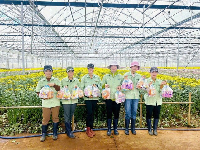 Les membres du syndicat et les employes de Dalat Hasfarm Co. Ltd. (province de Lam Dong) reçoivent avec enthousiasme des cadeaux de Noël. Photo : Lam Duc