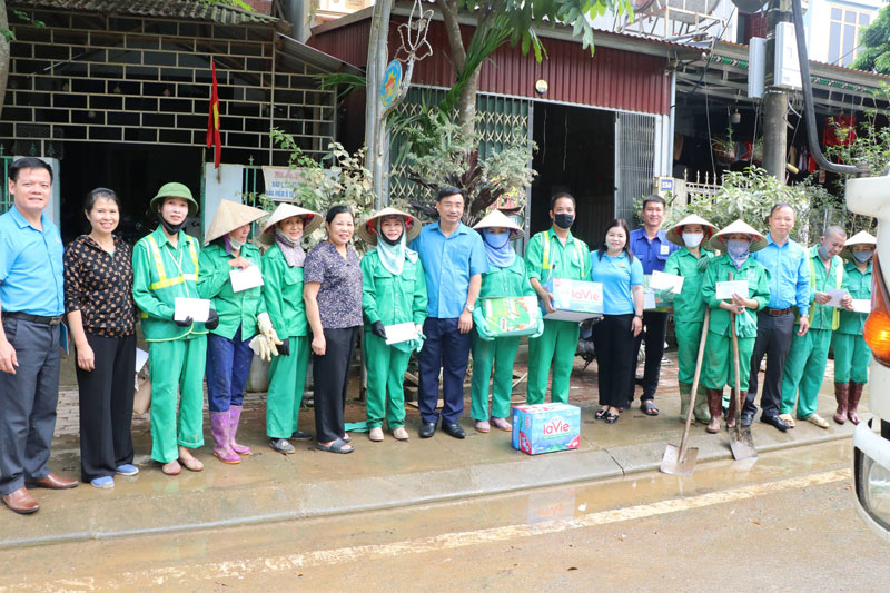 Lanh dao Lien doan Lao dong tinh Lao Cai tham dong vien va tang qua cho doan vien dang tham gia don dep ve sinh sau bao lu. Anh: Manh Hung  