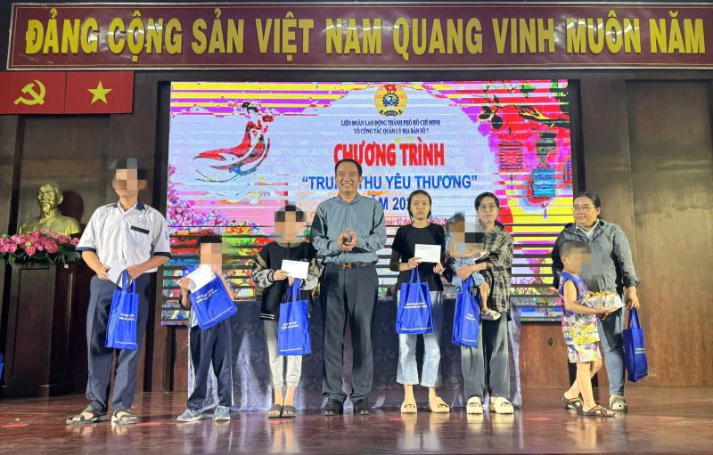 M. Dang Trung Dung - vice-president de la Federation du travail de Ho Chi Minh-Ville - remet des cadeaux de Noël aux enfants des membres du syndicat et des travailleurs. Photo : Duc Long