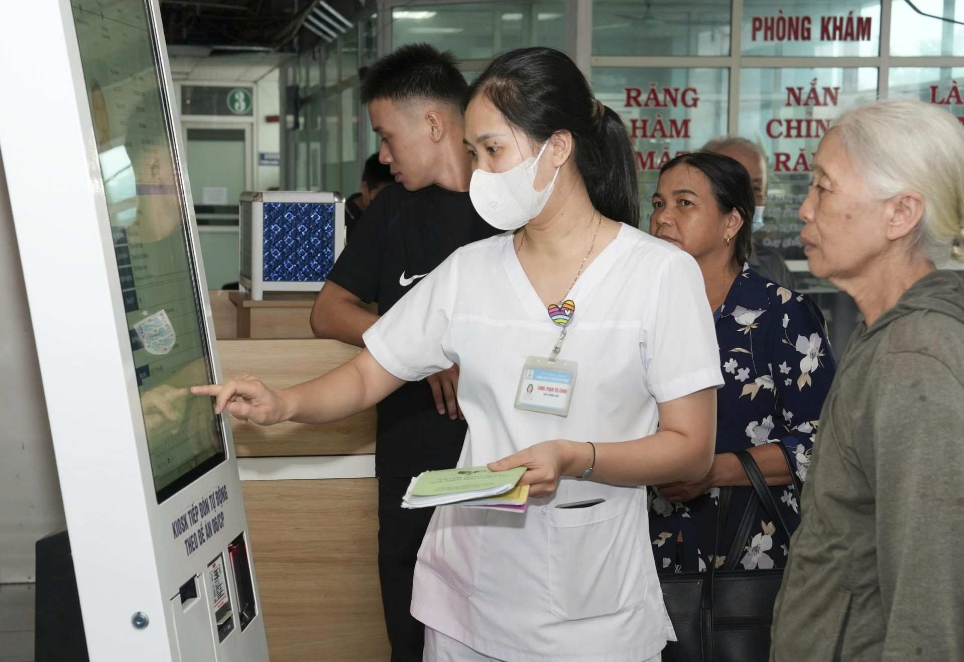 Can bo Trung tam Y te Kim Thanh huong dan nguoi cao tuoi khi di dang ky kham, chua benh. Ảnh: CDC Hai Phong