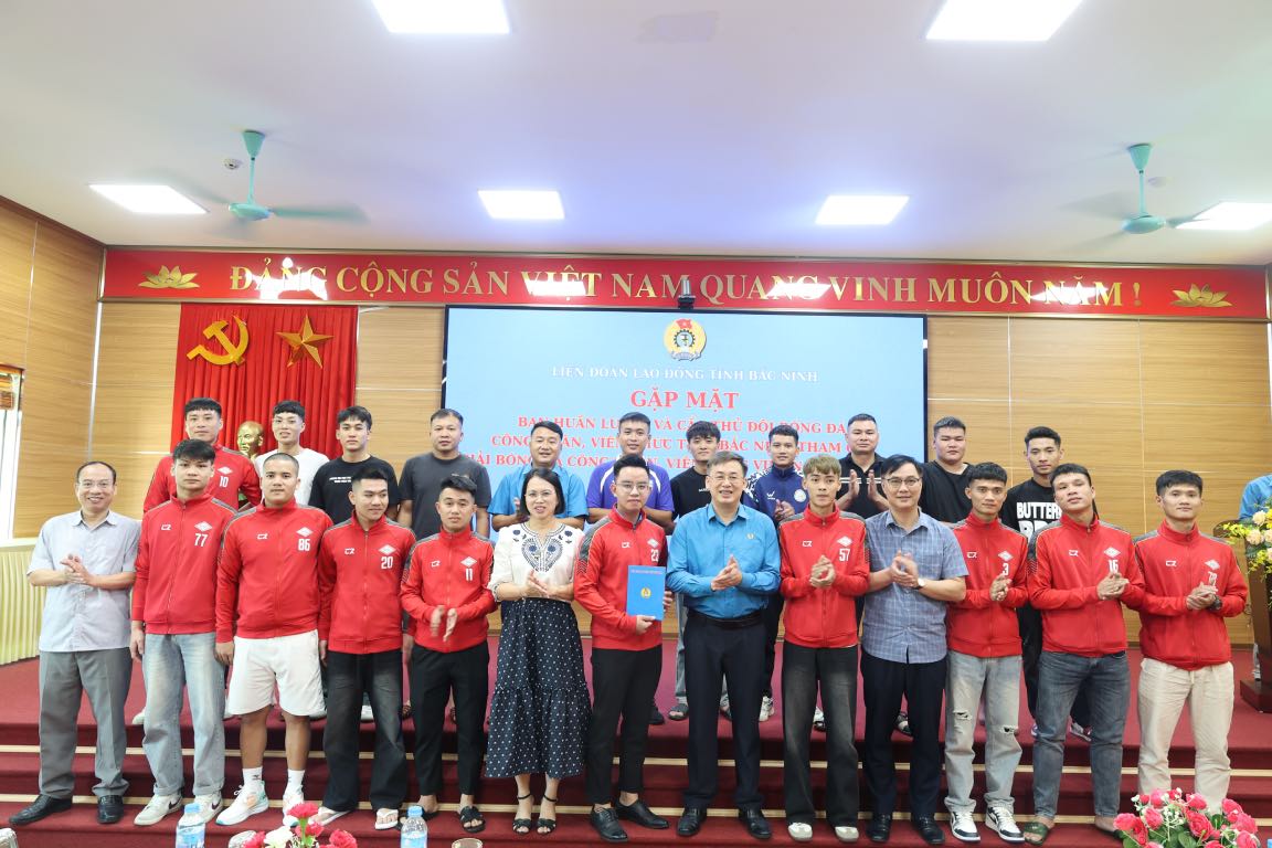 Les dirigeants de la Federation provinciale du travail prennent une photo souvenir avec les membres de l'equipe de football de Bac Ninh 2. Photo : Quyet Chien