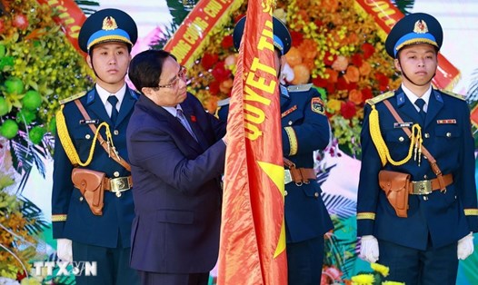 Ủy viên Bộ Chính trị, Thủ tướng Chính phủ Phạm Minh Chính gắn huy hiệu Anh hùng lực lượng vũ trang nhân dân lên Quân kỳ Quyết thắng của Quân chủng Phòng không - Không quân. Ảnh: TTXVN