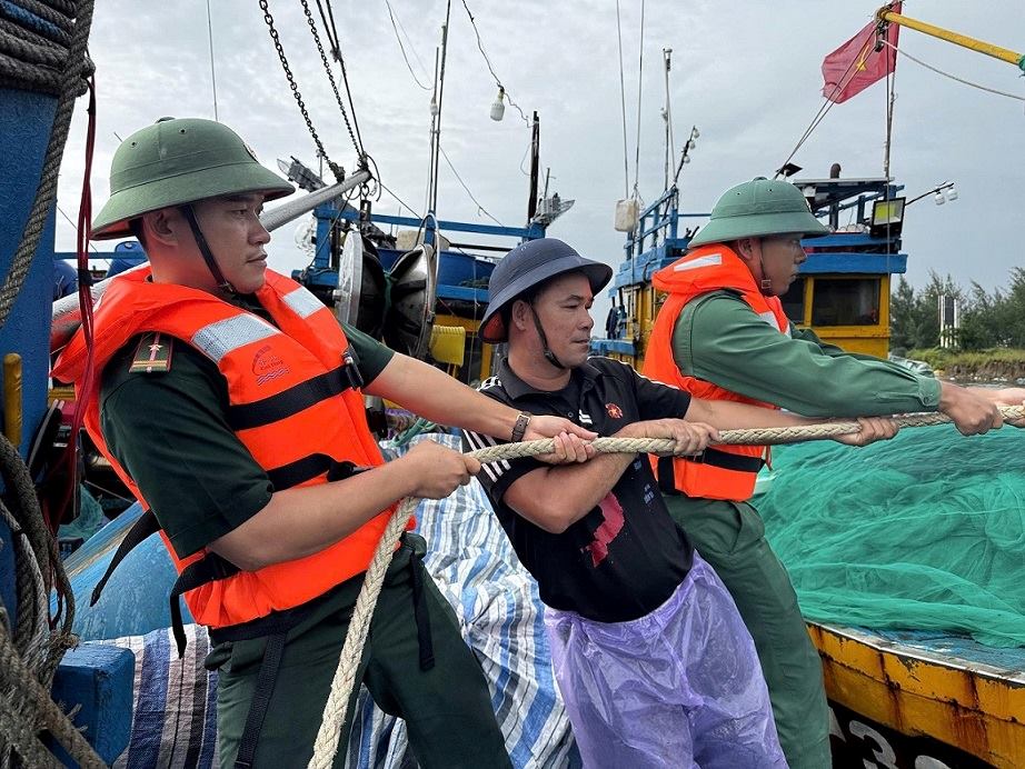 The Border Guard of Quang Ngai province helps fishermen tie their boats. Photo: Khanh Toan