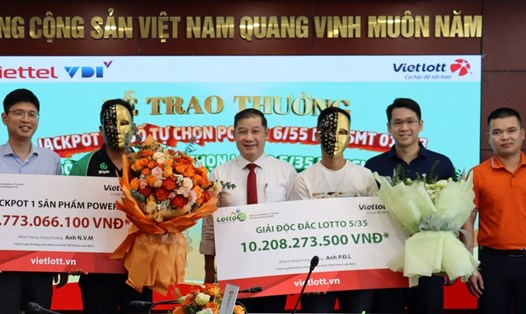 Anh N.V.M (áo xanh đen bên trái) nhận giải Jackpot 1 Power 6/55 kỳ QSMT 01253 và anh P.Đ.L (áo trắng bên phải) nhận giải Độc đắc Lotto 5/35 kỳ QSMT 00209. Ảnh: Vietlott