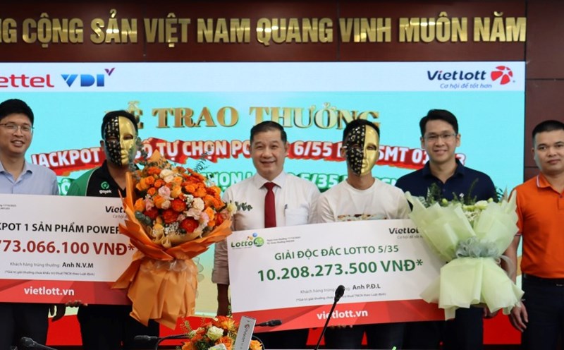 Mr. N.V.M (in blue shirt on the left) received the Jackpot 1 Power 6/55 QSMT 01253 and Mr. P.D.L (in white shirt on the right) received the Lotto 5/35 Golden Rooster QSMT 00209. Photo: Vietlott