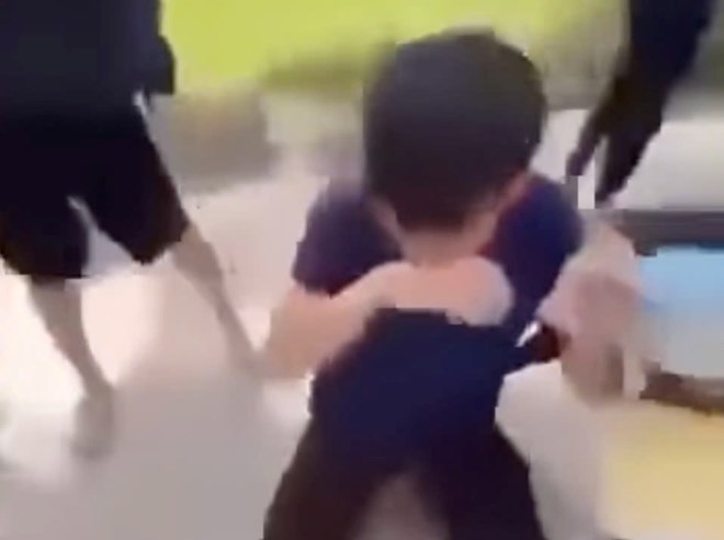 Nam sinh lop 10 Truong THPT Phu Minh (Ha Noi) bi mot nhom hoc sinh khac bat quy, liem bien so xe may. Anh: Cat tu clip
