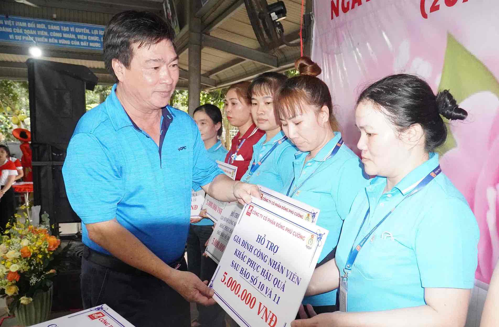 Ong Ngo Ngoc Thuan - Pho Giam doc Cong ty CP Dong Phu Cuong trao ho tro gia dinh cong nhan bi anh huong bao lu. Anh: HAC