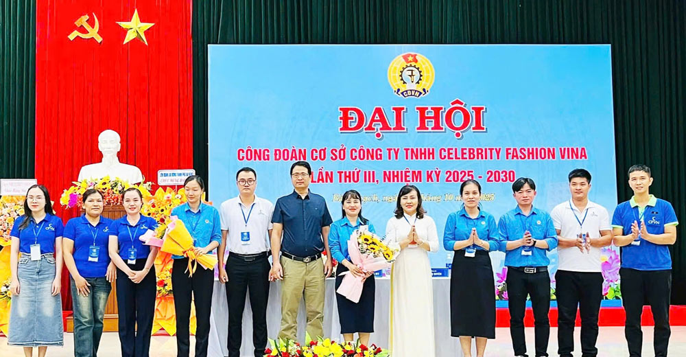 La Sra. Nguyen Thi Ngoc Anh vicepresidenta de la Federacion Laboral de la ciudad de Da Nang jefa de la zona sur (camisa larga) entrega flores para felicitar al Comite Ejecutivo del Sindicato de Base de Celebrity Fashion Vina Co. Ltd. para el mandato 2025-2030. Foto: Sindicato de Da Nang