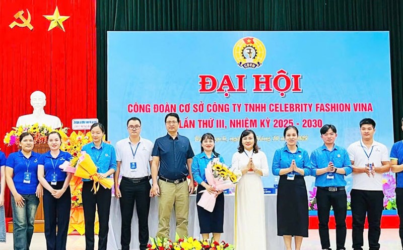 La Sra. Nguyen Thi Ngoc Anh vicepresidenta de la Federacion Laboral de la ciudad de Da Nang jefa de la zona sur (camisa larga) entrega flores para felicitar al Comite Ejecutivo del Sindicato de Base de Celebrity Fashion Vina Co. Ltd. para el mandato 2025-2030. Foto: Sindicato de Da Nang