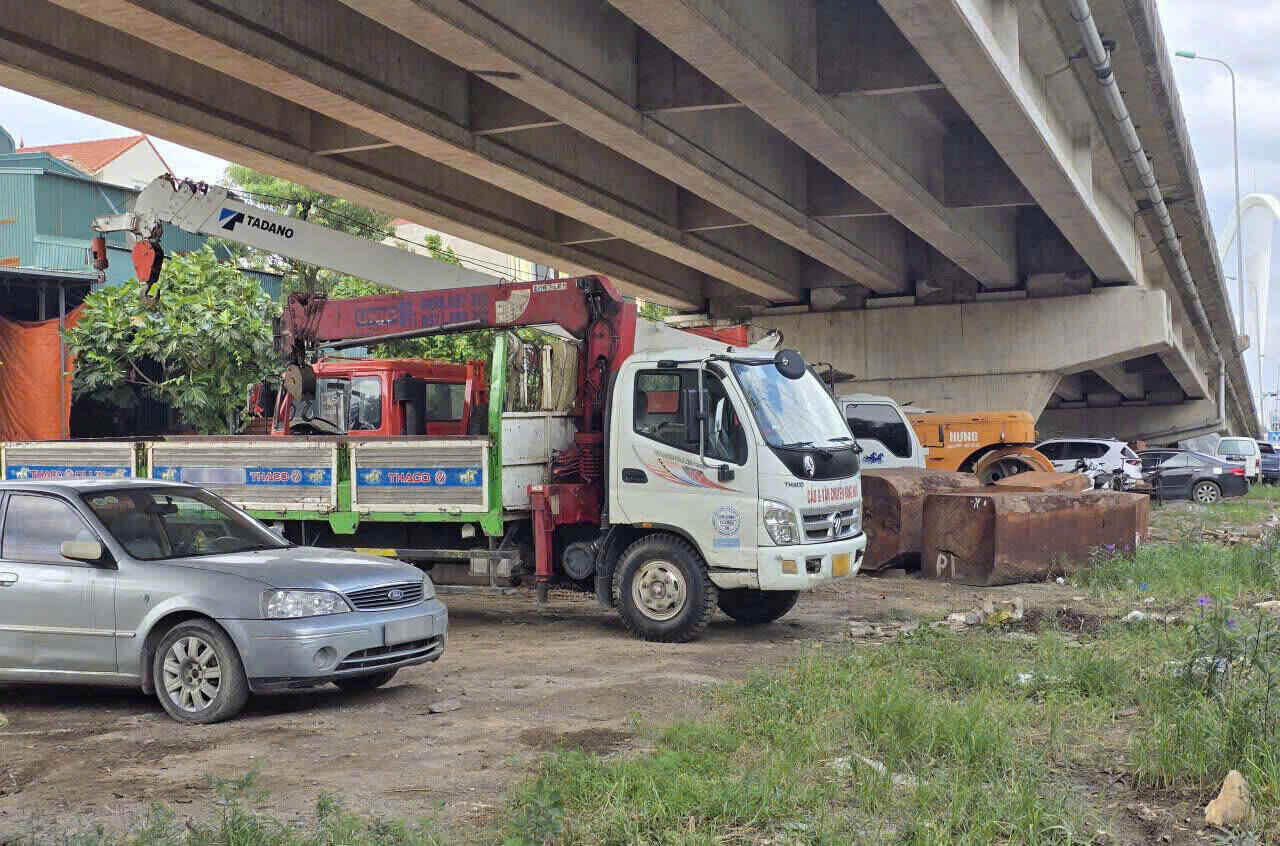 Khu vực gầm cầu vượt Ninh Phong (phường Nam Hoa Lư) đang bị người dân chiếm dụng làm nơi đỗ xe, bãi tập kết gỗ. Ảnh: Hà Vi