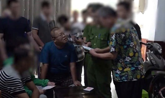 Đối tượng (áo xanh không che) bị Công an Trung Quốc truy nã được phát hiện đang lưu trú tại một khách sạn ở Nha Trang. Ảnh: Công an Khánh Hòa