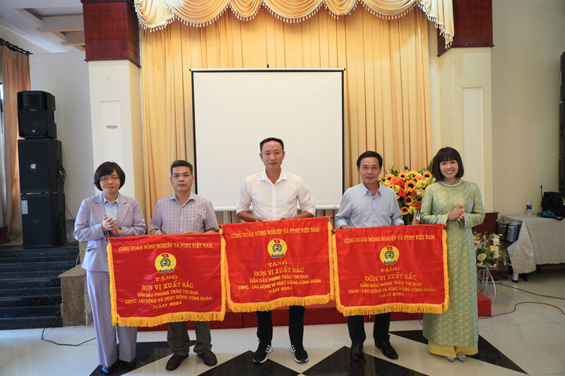 Ba Tran Thuy Nguyet - Chu tich Cong doan Tong cong ty Lam nghiep Viet Nam (ben phai) trao tang Co thi dua xuat sac cua Cong doan Nong nghiep va Moi truong Viet Nam cho cong doan co so. Anh: Duc Lam