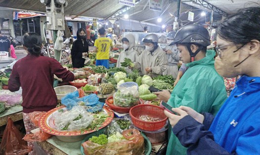 Người dân mua rau xanh ở chợ Hòa Cường (Đà Nẵng) tối 22.10. Ảnh: Thu Giang