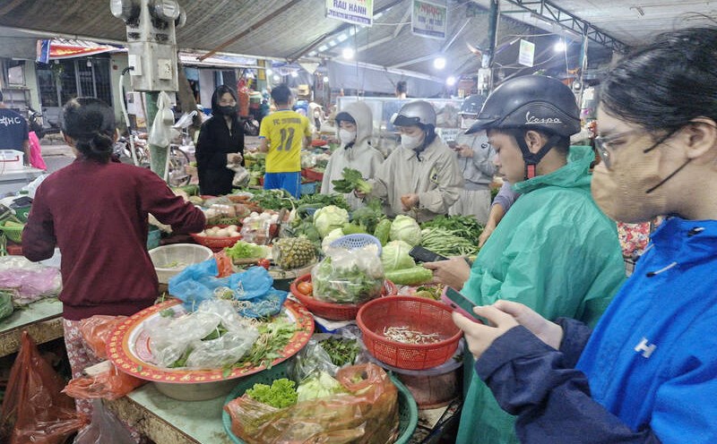 La gente compra verduras en el mercado de Hoa Cuong (Da Nang) en la noche del 22 de octubre. Foto: Thu Giang