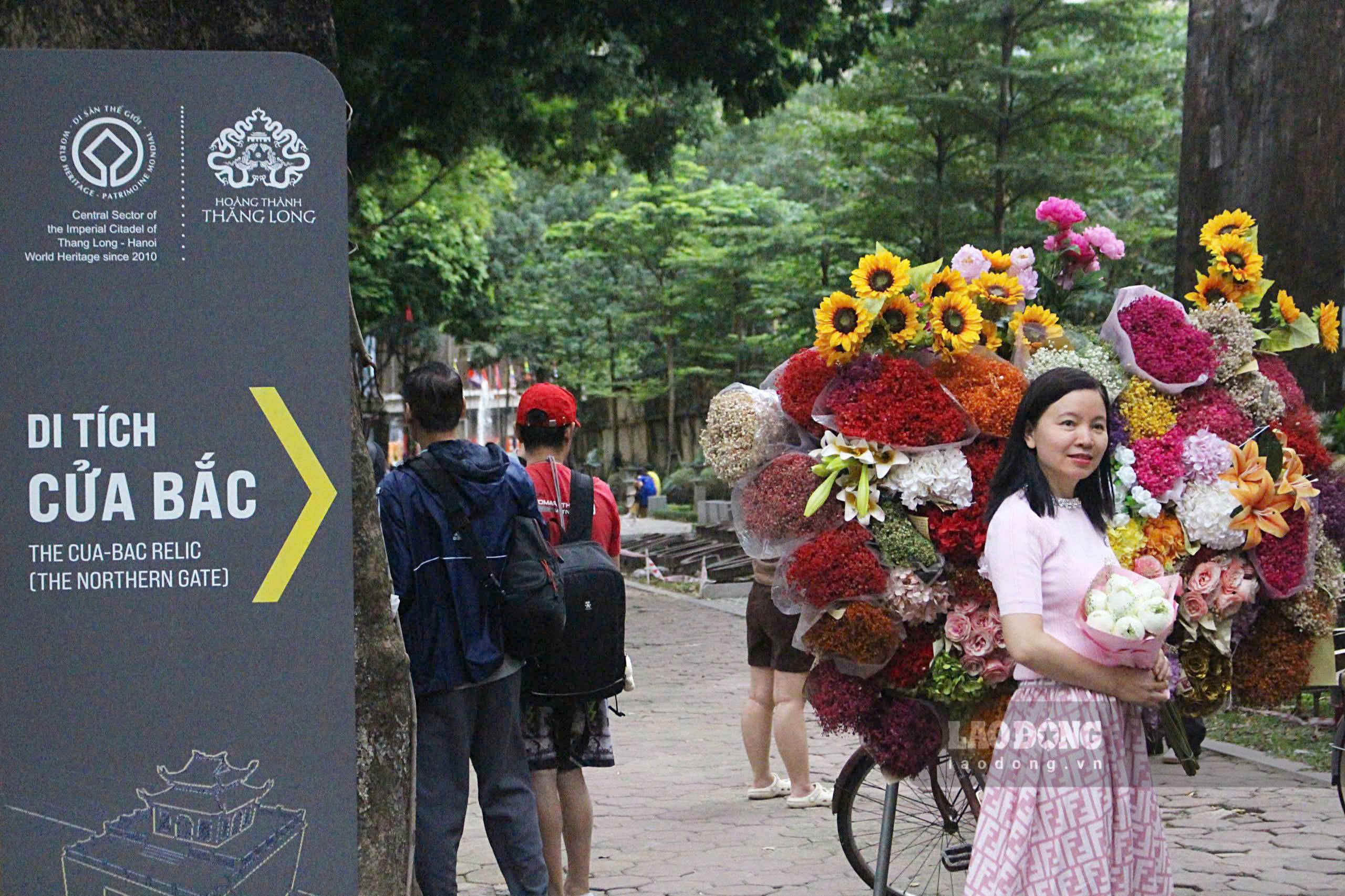 Tai pho Phan Dinh Phung - con duong duoc menh danh tho mong, tru tinh cua Ha Noi cung rat dong nguoi dan, du khach chup anh cung xe hoa. Day la hoat dong khong the bo qua moi dip Ha Noi vao thu. Duoi tan cay xanh lap lanh anh nang, nhung xe hoa gian di xep hang dai, voi phia sau xe chat day nhung bo hoa ruc ro du loai: sen, cuc, hong…