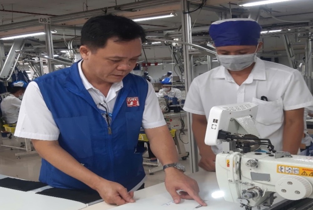 Anh Phan Van Vi (ao xanh) huong dan cong nhan moi vao nghe. Anh: LDLD tinh Dong Thap.  