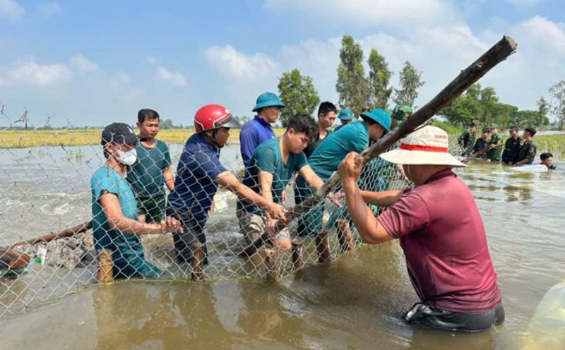 The authorities coordinated with the people to reinforce, protect, and fix the dike breach. Photo: Duy Minh