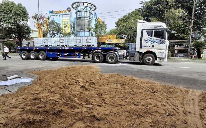 Authorities in Quang Ngai use sand to fill the amount of chemicals flowing onto the road surface. Photo: Vien Nguyen