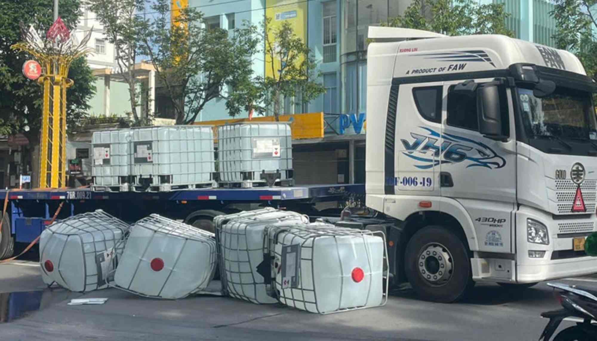 4 thung trên xe bất ngờ bi dổ xuống dường o Quang Ngai, khiến dung dich trong binh tran ra măt dường. Anh: Nguyen Thanh