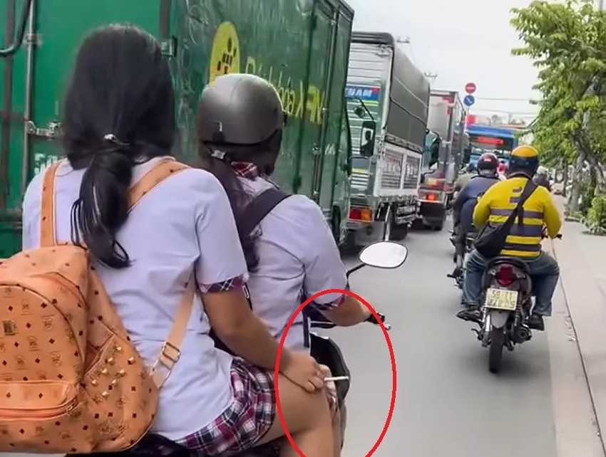 Traffic police are verifying that the female student riding a motorbike did not wear a helmet or hold a cigarette in Ho Chi Minh City. Photo: Dong Hoang