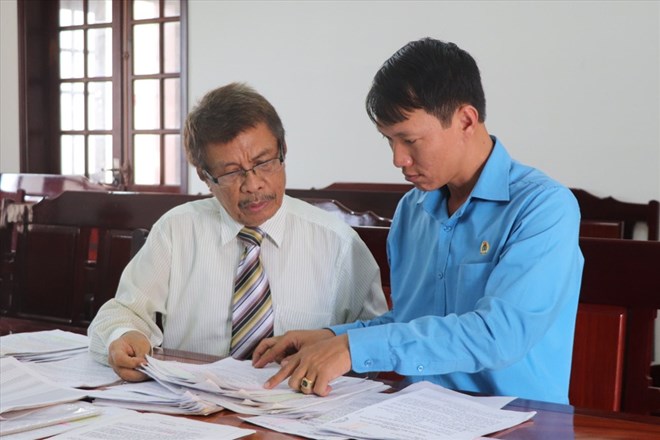 Ong Vu Ngoc Ha - Giam doc Trung tam Tu van phap luat Cong doan - LDLD tinh Dong Nai (ben phai) dang ho tro phap ly cho mot nguoi lao dong. Anh tu lieu: HAC