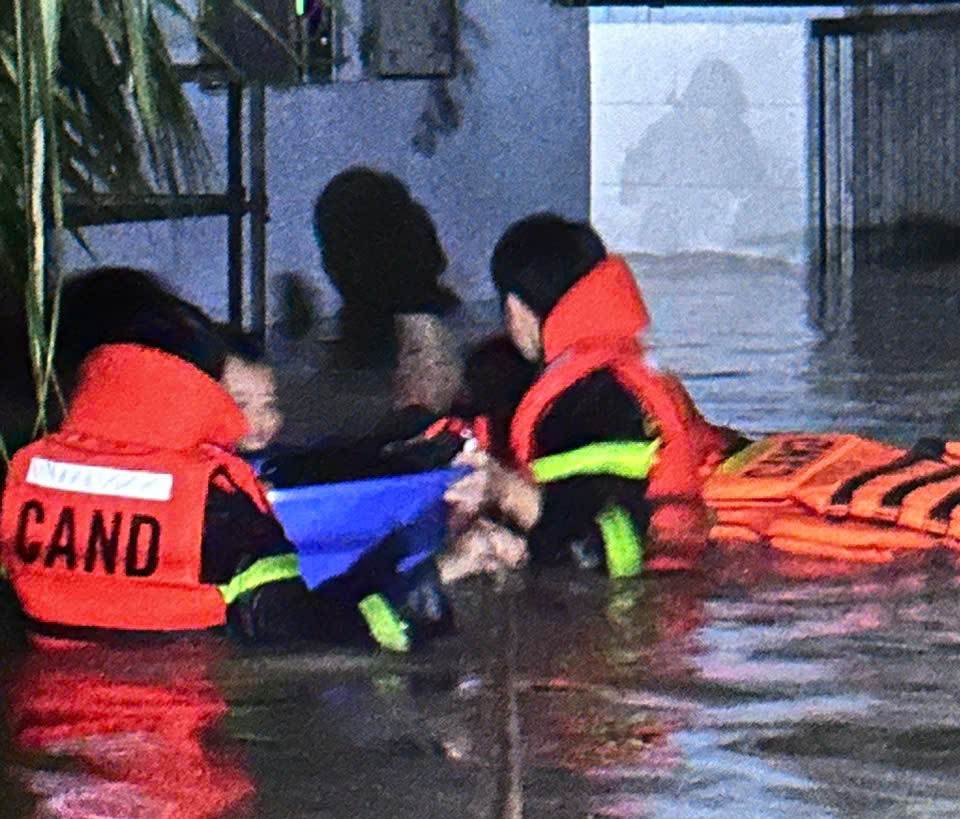 Luc luong cuu ho dua nguoi dan bi mat ket trong vung nuoc lu dang cao o Ben Cat, TPHCM den noi an toan. Anh: Co quan chuc nang cung cap