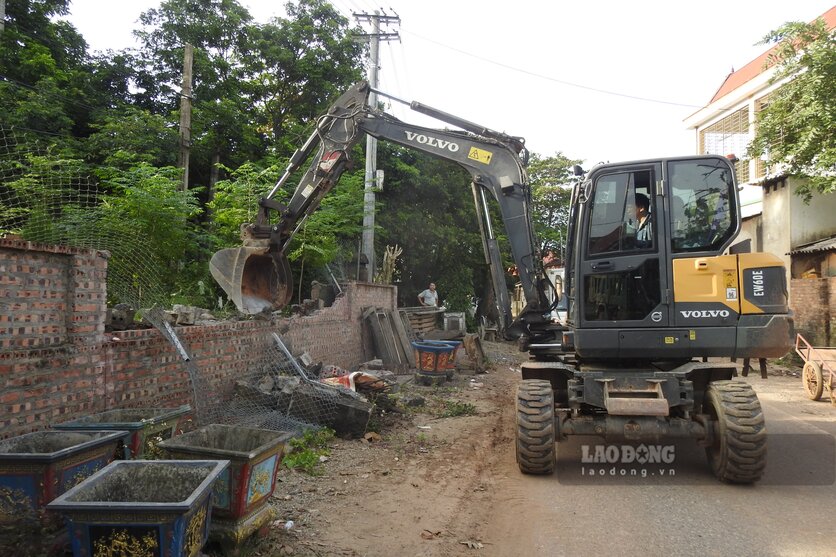 Ông Đạt đang phá bỏ tường rào ven đường. Ảnh: Tô Công.