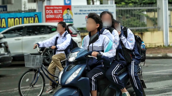 Students drove a car carrying 3 people, violating the law without wearing a helmet. Photo: Huy Khanh