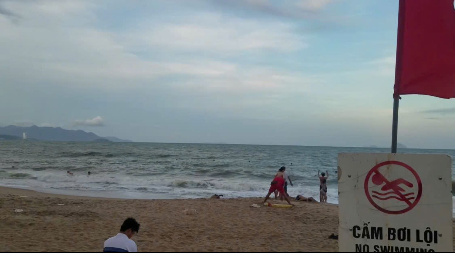 Although the authorities have put up signs prohibiting swimming in areas at risk of high waves on the coast of Nha Trang, there are still people swimming. Photo: Duy Vu