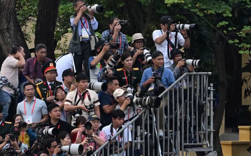 Reporter working at the A80 event (left photo). Photo: Hai Nguyen
