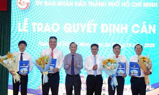 Lãnh đạo TPHCM trao quyết định và tặng hoa chúc mừng Chủ tịch, Phó Chủ tịch UBND các phường, xã.  Ảnh: Minh Quân