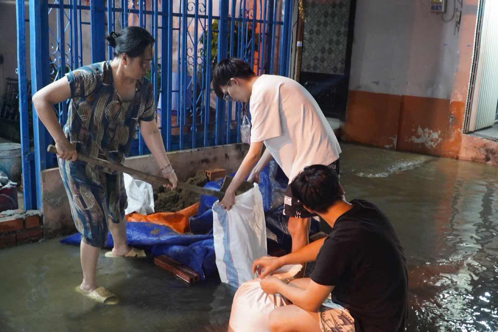 Nguoi dan xuc cat de dap bao chan truoc cua, ngan nuoc trieu tran vao nha. Anh: Thai Bao