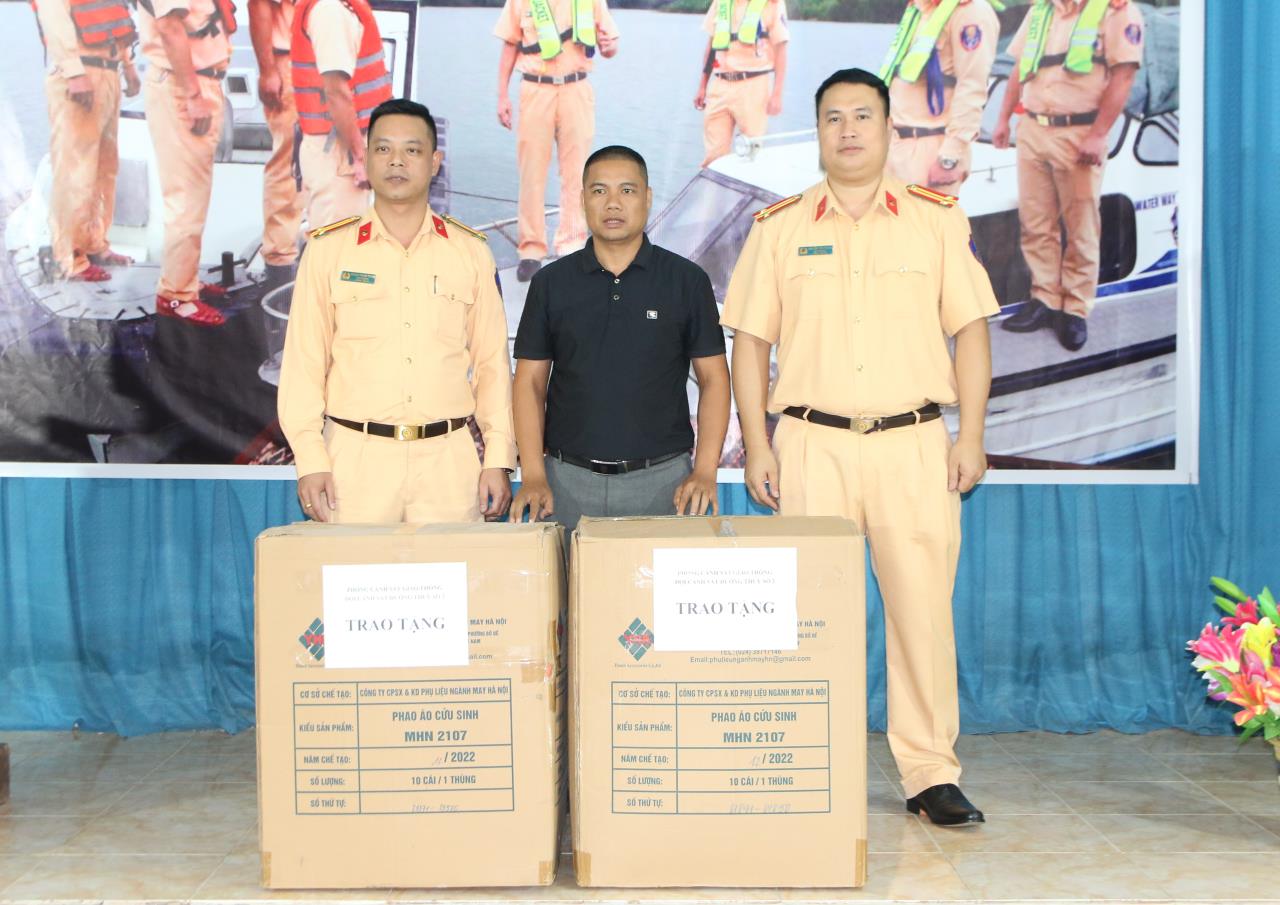 Lanh dao Doi CSGT Duong thuy so 2 trao ao phao ho tro cac don vi kinh doanh dich vu van tai tren tuyen ho Thac Ba. Anh: Van Duc