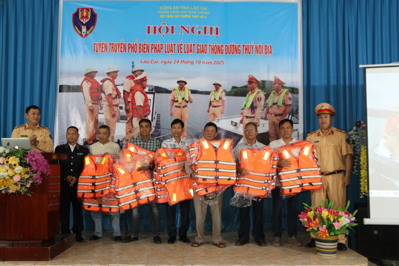 Lanh dao Phong CSGT Cong an tinh Lao Cai trao ao phao cho cac don vi, doanh nghiep. Anh: Van Duc