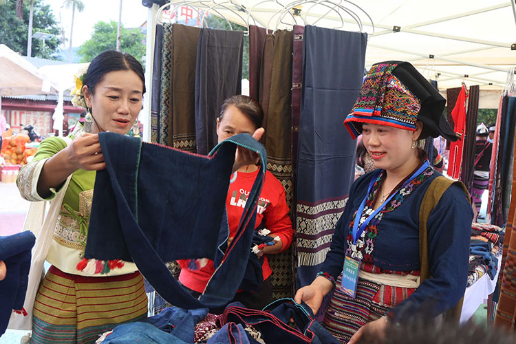 People and tourists visit Lao ethnic brocade products of Dien Bien province. Photo: Giang Nam