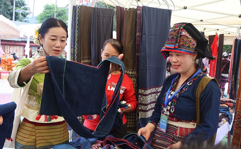 People and tourists visit Lao ethnic brocade products of Dien Bien province. Photo: Giang Nam