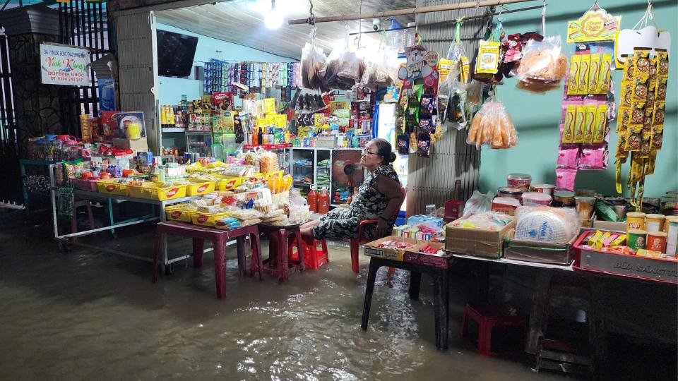 タンハン区の食料品店に洪水を防ぐための物品を設置する人々。写真: ホアン・ロック