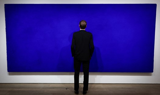 Một nhân viên nhà đấu giá Christie's đang xem bức tranh California của họa sĩ người Pháp Yves Klein, được trưng bày tại nhà đấu giá Christie's ở Paris. Anh: AFP