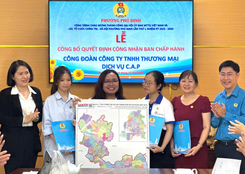 Representatives of Phu Dinh Ward Trade Union congratulated and presented the administrative map of Ho Chi Minh City to the Executive Committee of the Trade Union of C.A.P Trading and Service Company Limited. Photo: Duc Long