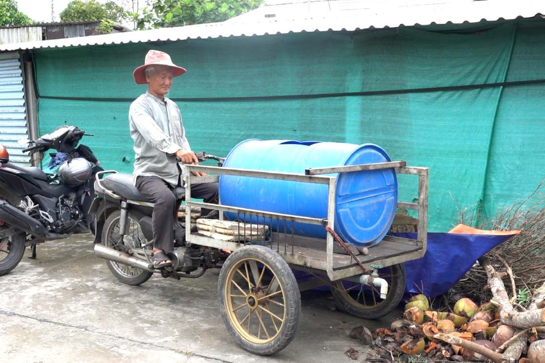 Chiec xe gan thung phi chua nuoc giup tuoi cay doc duong, va chiec xe dap phun thuoc diet sau benh cho hang cay ven duong. Anh: Ta Quang