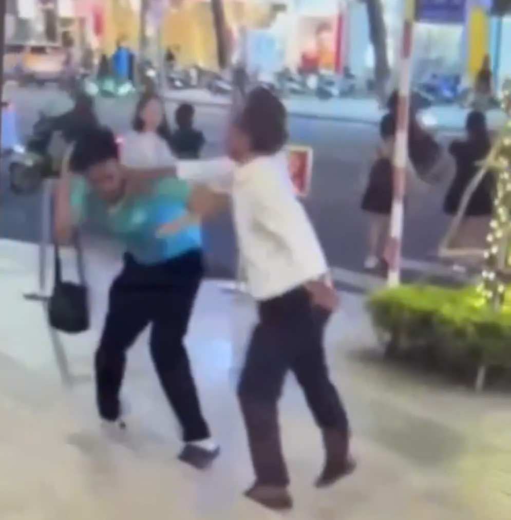 Clip recorded by local residents shows an elderly man in Nha Trang hitting a phone on the taxi driver's head. Photo: Huu Long