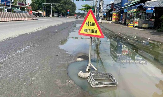 Đường ĐT 744 đoạn qua phường Tây Nam, TPHCM bị hư hỏng, người dân mang bảng ra cảnh báo. Ảnh: Đình Trọng