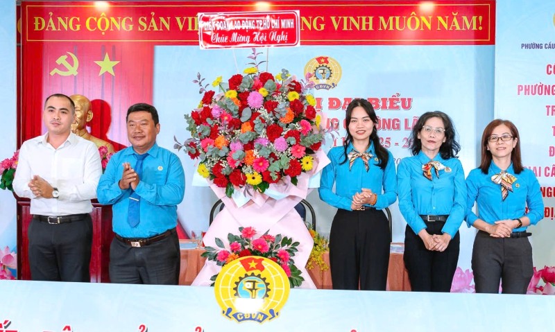 Le representant de la Federation du travail de Ho Chi Minh-Ville offre des fleurs pour feliciter la conference des representants du syndicat du quartier de Cau Ong Lanh. Photo : Duc Long