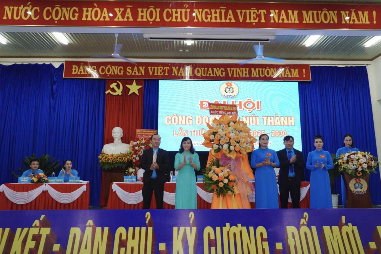 Nguyen Thi Ngoc Anh 다낭시 노동총연맹 부위원장이 2025-2030 임기 동안 누이탄 코뮌 노동조합 제1차 대회를 축하하며 꽃을 전달하고 있습니다. 사진: Tran Thi