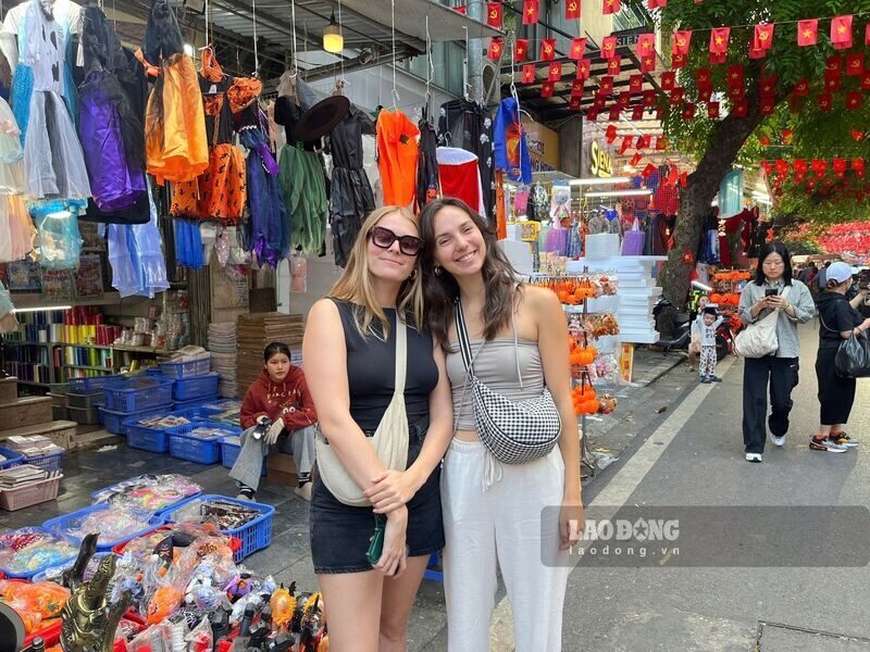 Hai du khach nguoi Phap bat ngo khi vua trai nghiem ca le hoi Halloween lan Giang sinh tren cung mot khu pho. Ảnh: Tuong Vy