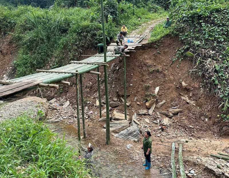 Luc luong Cong an cung nguoi dan van chuyen vat lieu dung cau tre. Anh: Cong an Cao Bang