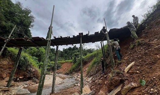 Công an xã Đức Long cùng người dân dựng cầu tre, phục vụ đi lại. Ảnh: Công an Cao Bằng