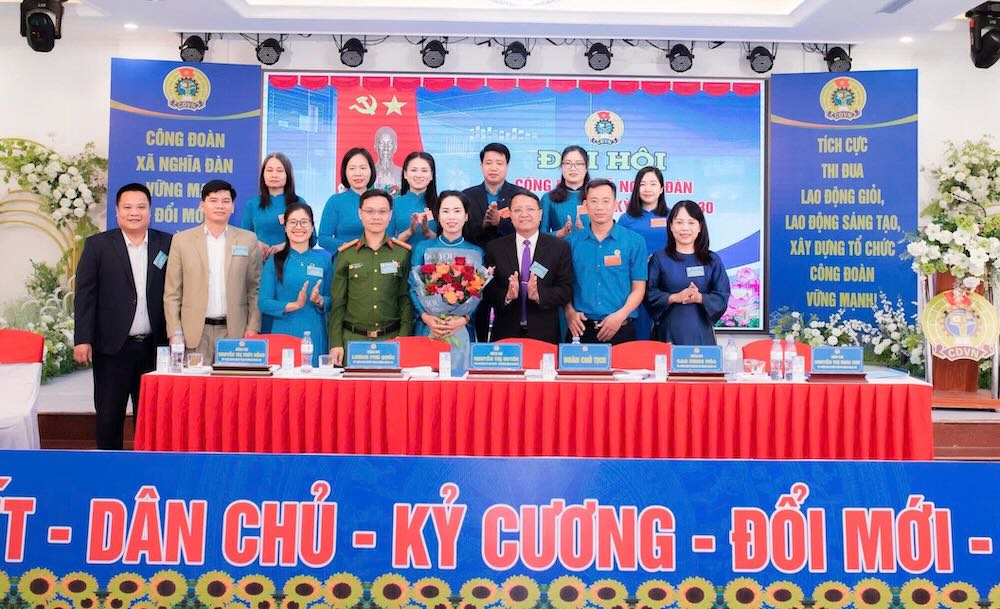 지도부 대표가 2025-2030 임기 제1기 Nghia Dan 면 노동조합 집행위원회에 꽃다발을 전달하며 축하하고 있습니다. 사진: Nghe An 노동조합