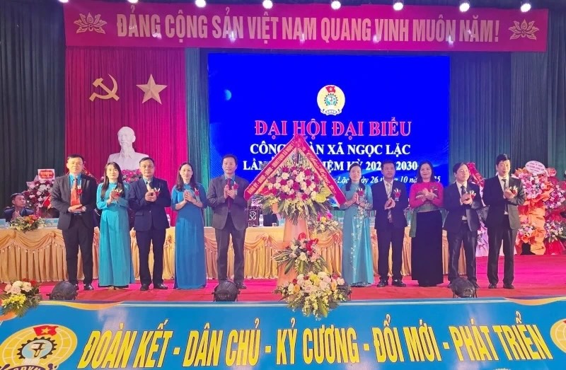 Ngoc Lac 코뮌 지도자들이 코뮌 노동조합 대회를 축하하며 꽃을 전달합니다. 사진: T. Hue